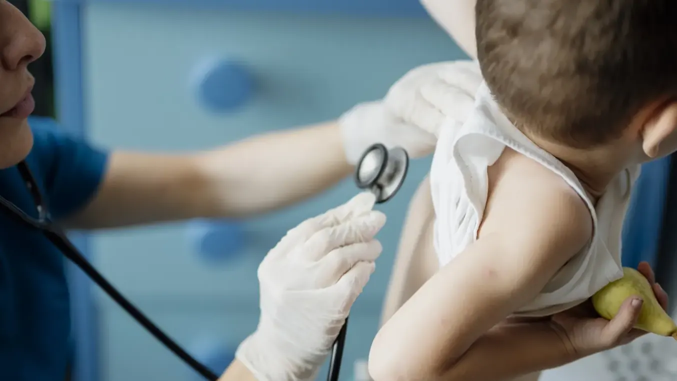 A child being examined with a stethoscope during a consultation.